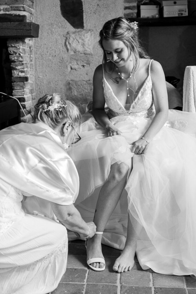 maman qui atache les chaussures de sa fille en robe de mariée Chambéry